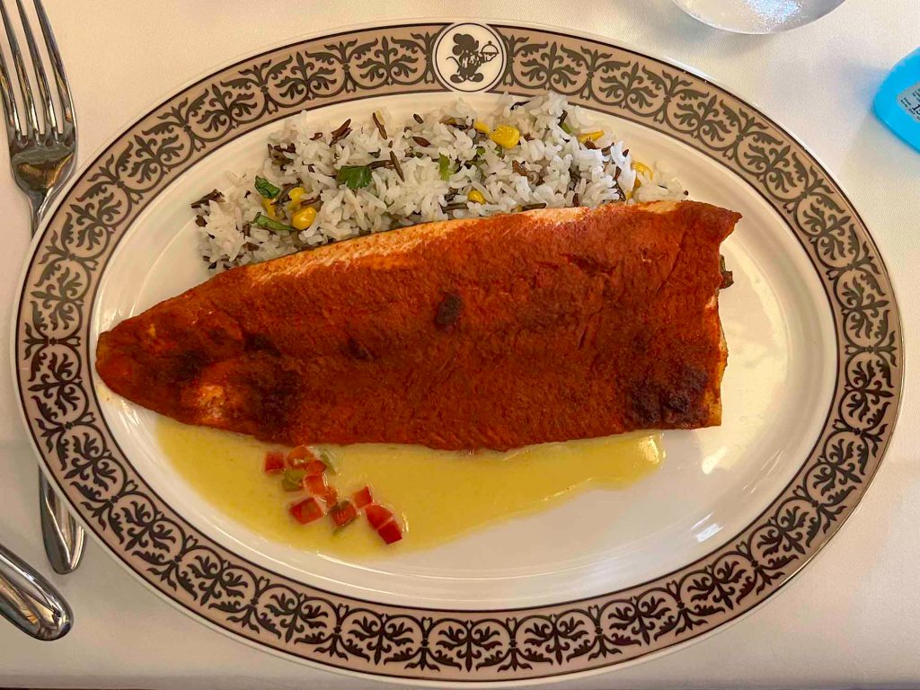 Cajun-Spiced Arctic Char, Wild Rice with Corn and Coriander, Isigny Butter Sauce in Walt’s - an American restaurant at Disneyland Paris, 2022.